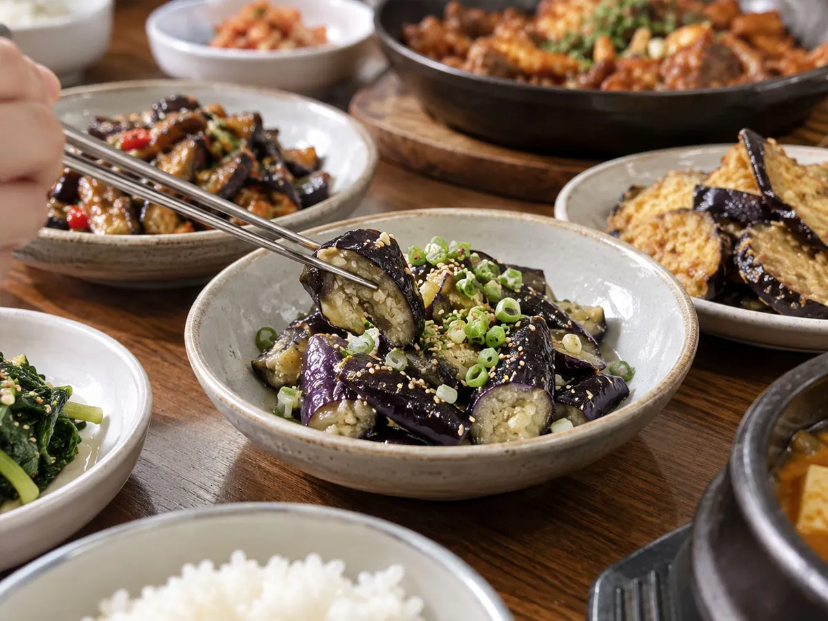 담백하게 무친 가지를 젓가락으로 집어 먹는 장면으로 가지 반찬의 활용을 표현한 사진.<br>
