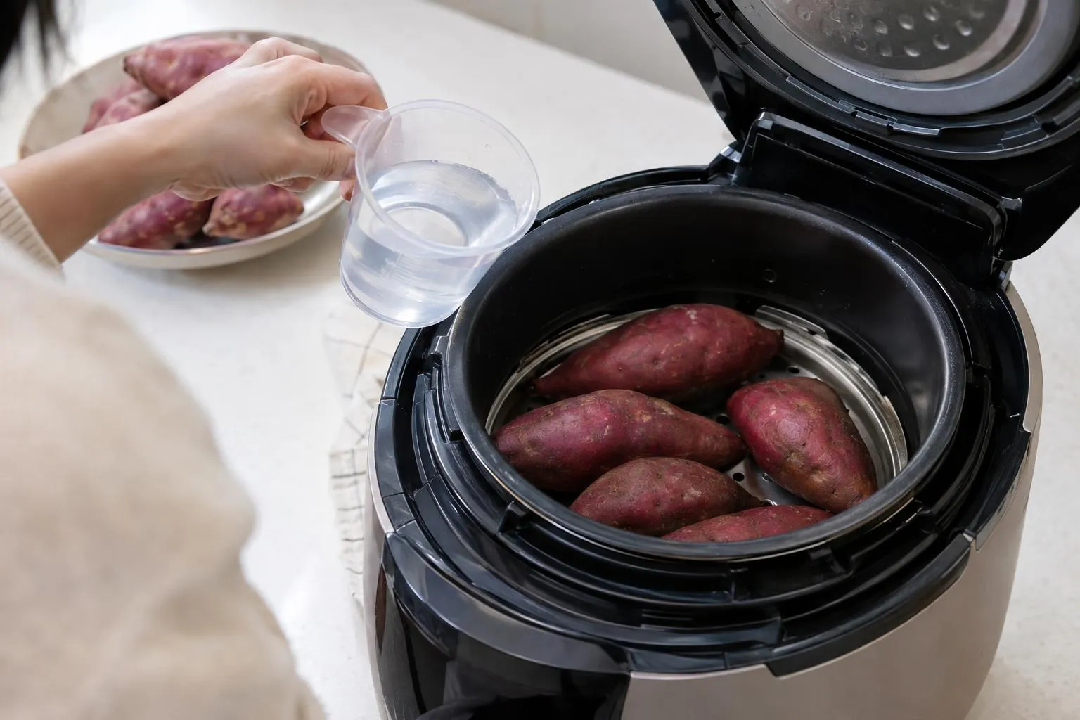 밥솥 만능찜 기능으로 고구마를 부드럽게 익히는 모습.