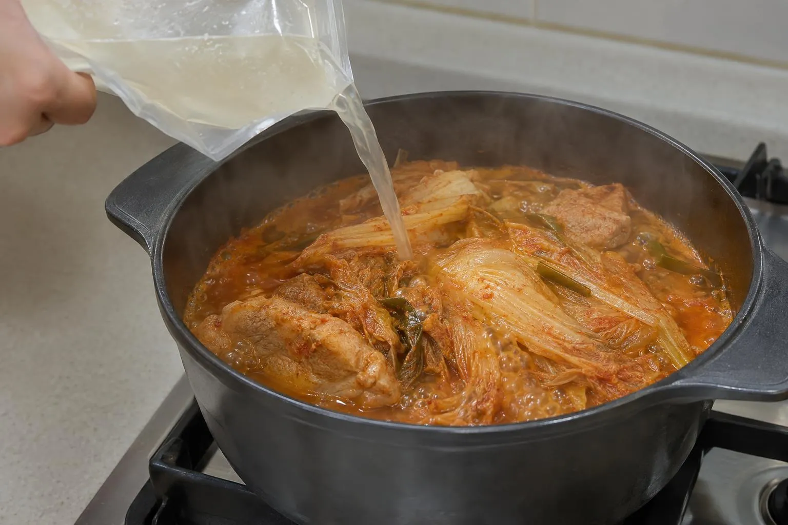 냉면 육수와 물을 섞어 김치찜을 약불에서 1시간 끓이는 모습.